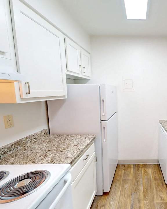 a kitchen with white cabinets and granite counter tops