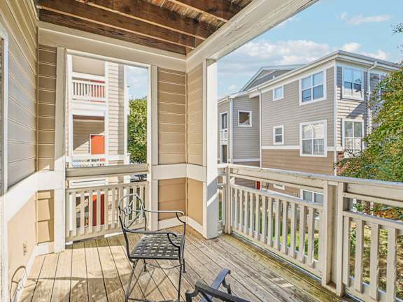 A balcony with a table and chairs overlooking a residential area.
