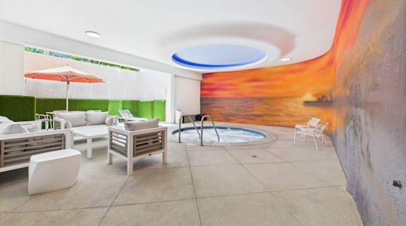 A modern outdoor seating area with a pool and a mural on the wall.