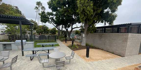 A patio with a table and chairs and a tree.