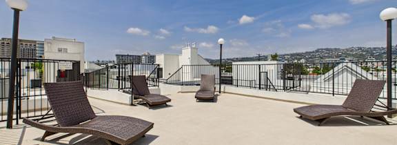 A patio with four chairs and two lamps.