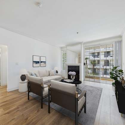 A living room with a white couch and a black chair.