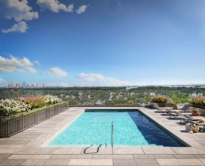 a swimming pool on a roof with a city in the background