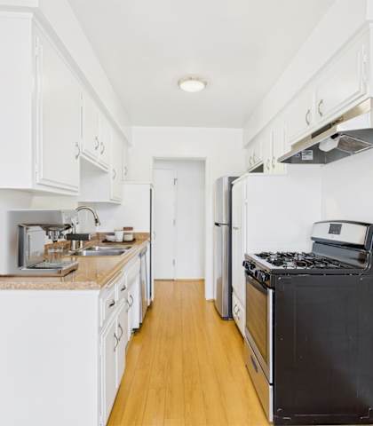 A kitchen with white cabinets and a black stove top oven.