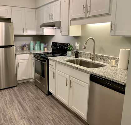 A kitchen with a stainless steel refrigerator and a black dishwasher.