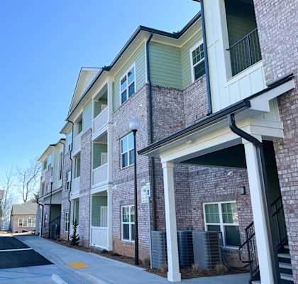 A row of townhouses with a clear blue sky above.