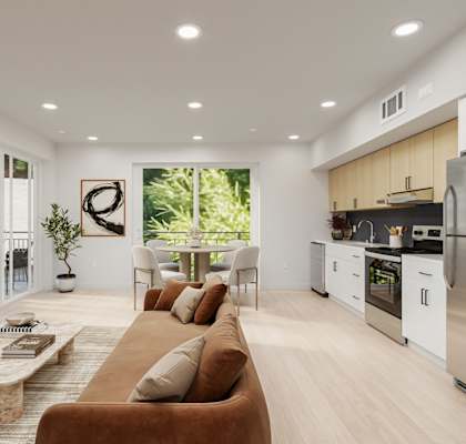 A modern living room with a brown sofa and a kitchen in the background.