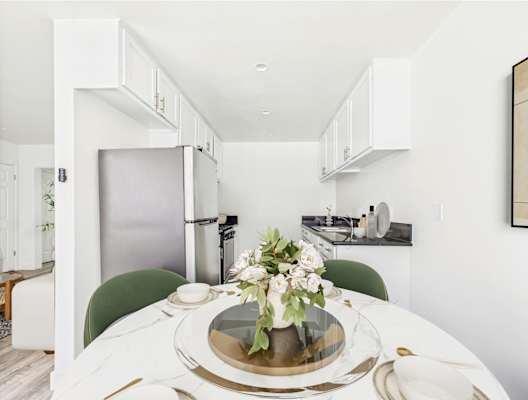 A modern kitchen with a table set for two.