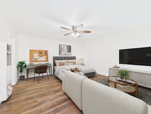 A bedroom with a bed, a desk, and a couch.