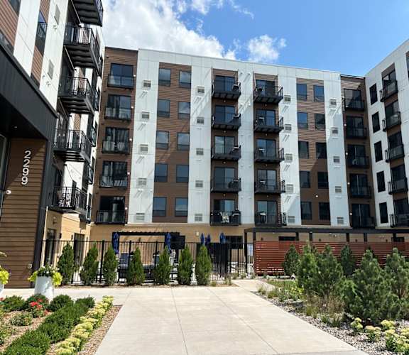 a large apartment building with a concrete walkway in front of it
