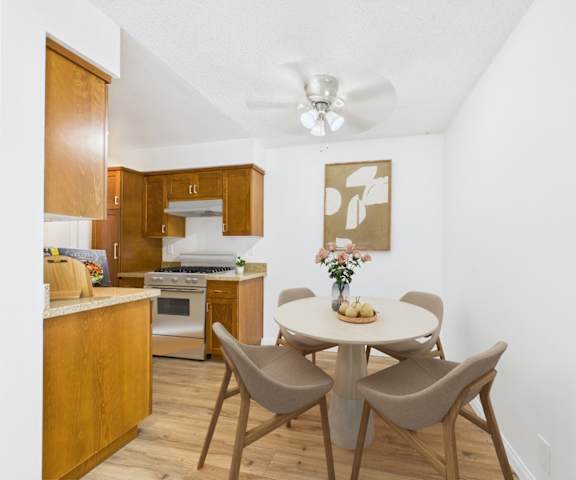 A kitchen with a table and chairs.