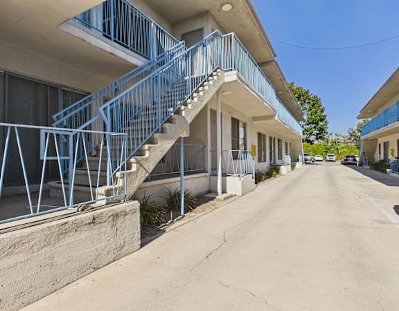 A blue staircase leads to a building entrance.