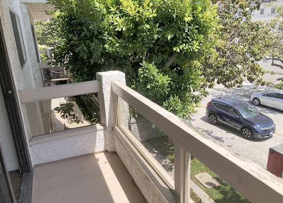 Exterior aerial view of an apartment building with cars parked.