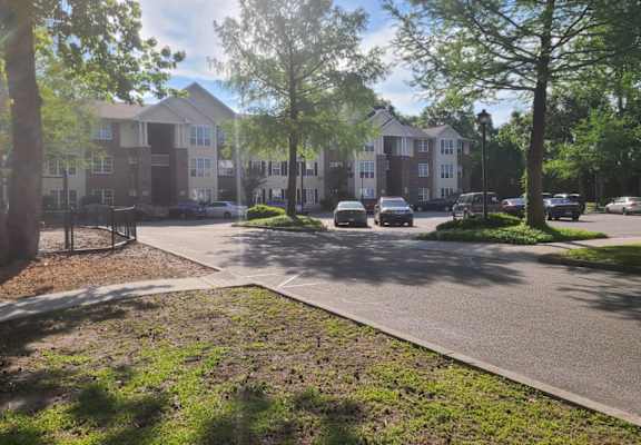 an apartment building with cars parked in a parking lot