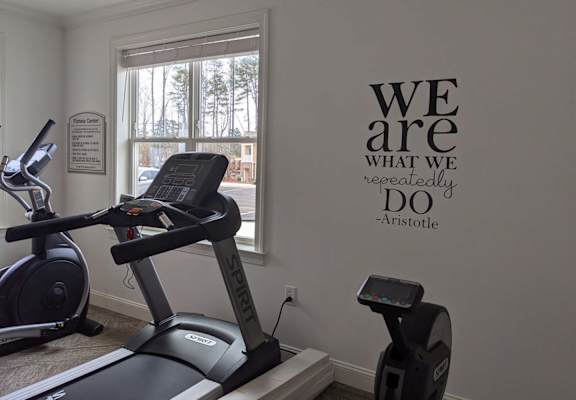 a gym with a exercise bike in a room with a window