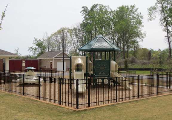 a playground at a park with a black fence