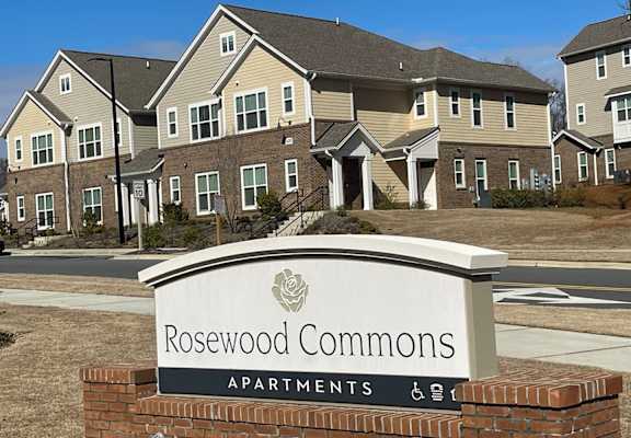 a sign in front of a row of apartment buildings