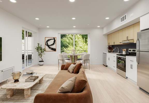 A modern living room with a brown sofa and a kitchen in the background.