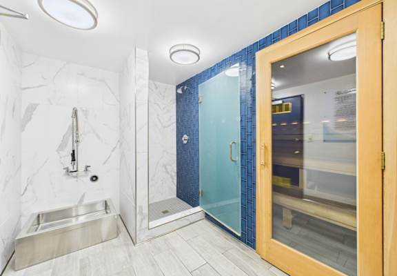 A bathroom with a sink, mirror, and shower.
