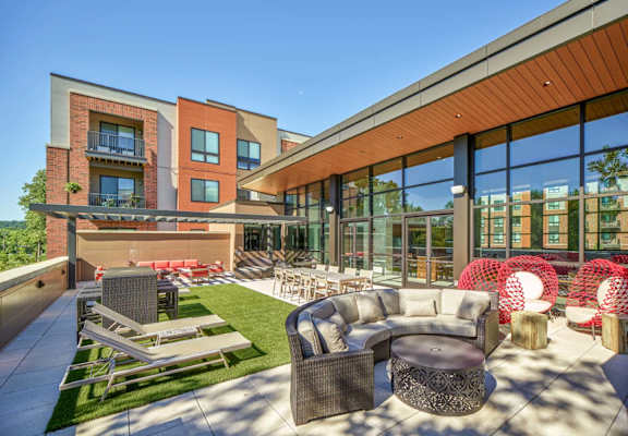A modern outdoor seating area with a variety of chairs and tables.