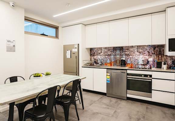 a kitchen with white cabinets and a table with black chairs