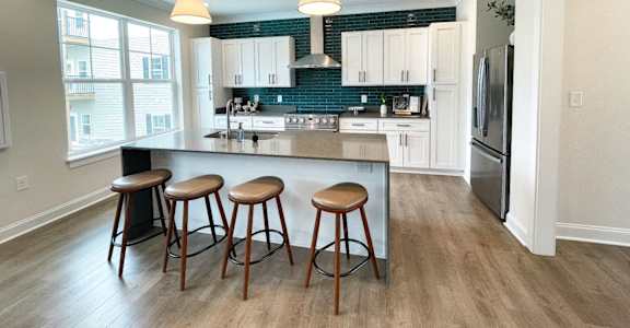 A kitchen with a bar area and a refrigerator.