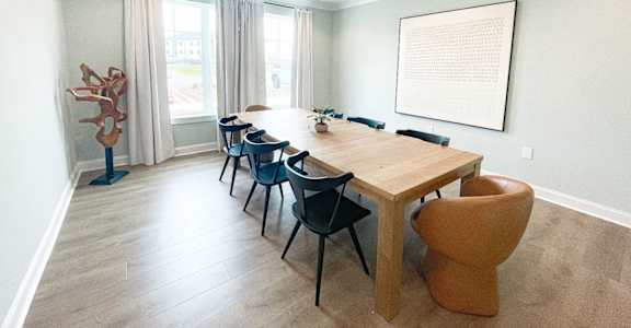 A dining room with a wooden table and chairs.