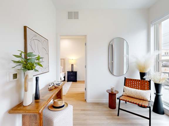 A room with a chair and a mirror on the wall.