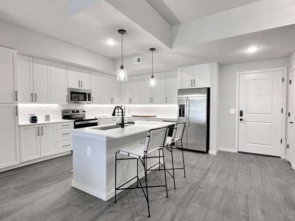 Matte black fixtures and hardware, trendy tile backsplashes and wine coolers in kitchen