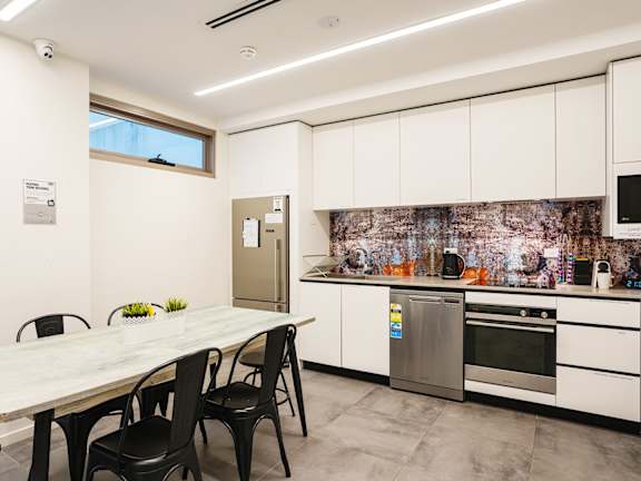 a kitchen with white cabinets and a table with black chairs