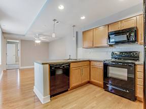 A kitchen with wooden cabinets and black appliances.