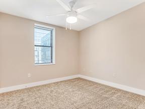 A room with a ceiling fan and a window.