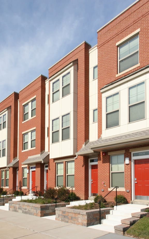 a row of houses with a sidewalk in front of them