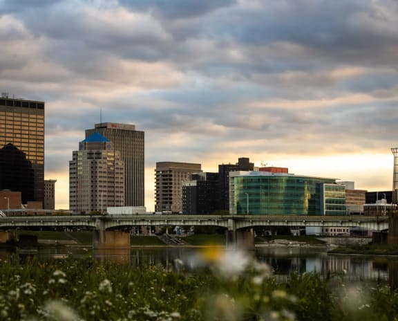 a cityscape with a bridge in the foreground and a river in the background