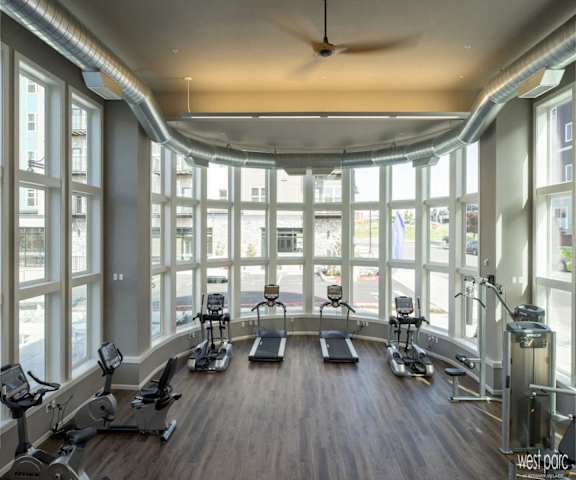 a fitness room with windows and exercise machines