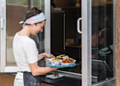 Thumbnail 32 of 46 - A woman is holding a plate of food at Bautista Apartments, Tucson, 85745