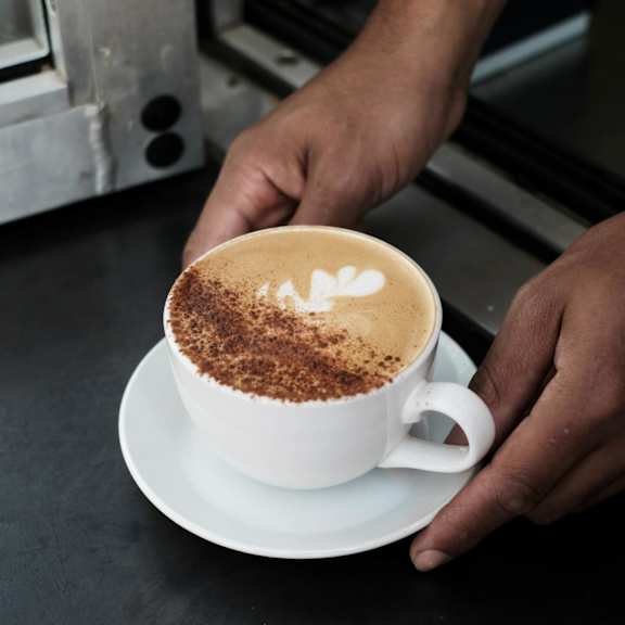 A person is holding a cup of coffee at Bautista Apartments, Arizona