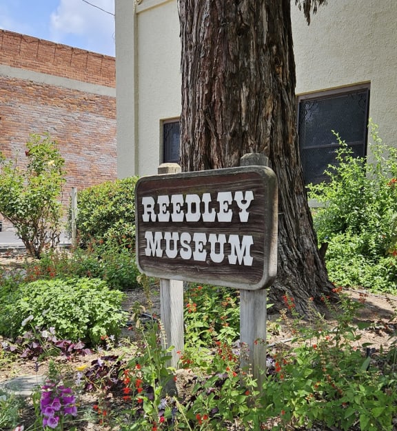 a sign for the reliability museum in front of a tree