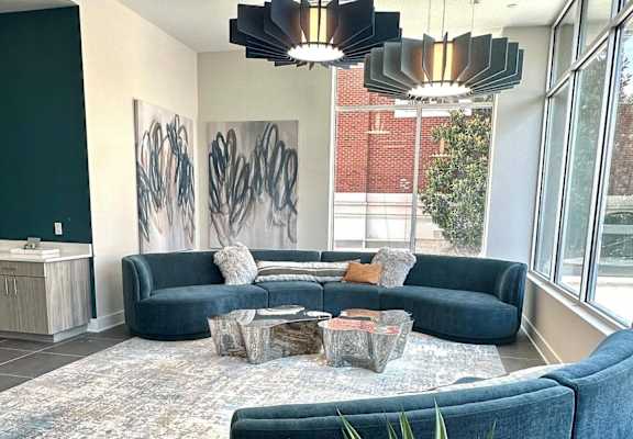 A living room with a blue couch and a rug.