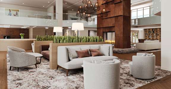 a lobby with a couch and chairs and a rug