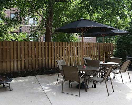 A patio with a table and chairs under an umbrella.
