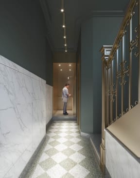 a man standing in a hallway with a door open at East 4th Street, Cleveland, 44115