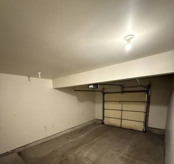 A white wall with a light on and a door in the middle.