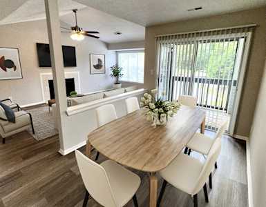 a dining room and living room with a table and chairs