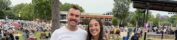 A man and a woman are standing in front of a tree wearing white t-shirts with the word "NEEHLY" printed on them.