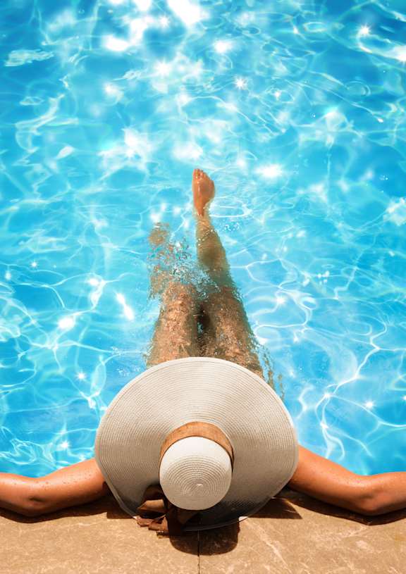 Woman wearing white hat and sitting in pool at Vista Condominiums, Kansas City, KS