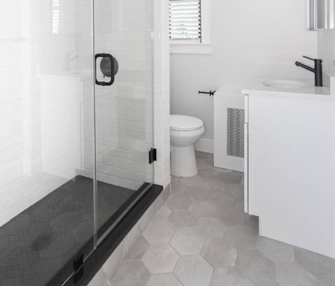 a white bathroom with a shower and a toilet