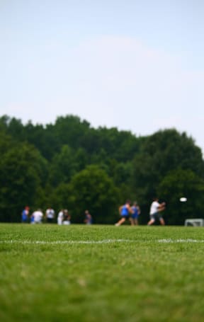 a group of people playing frisbee on a field