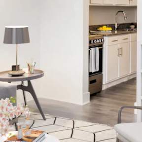 a living room with a couch and a table and a kitchen