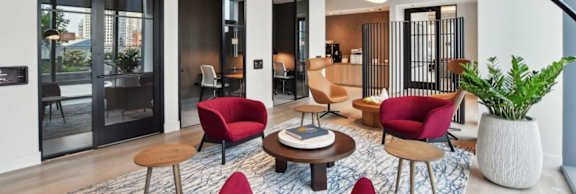 A modern living room with red chairs and a wooden coffee table.
